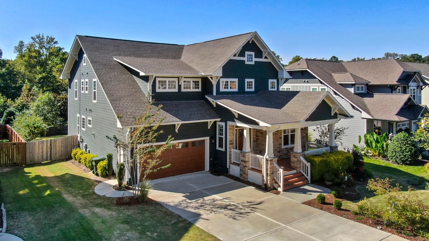 A craftsman-style home with a covered front porch on a sunny day