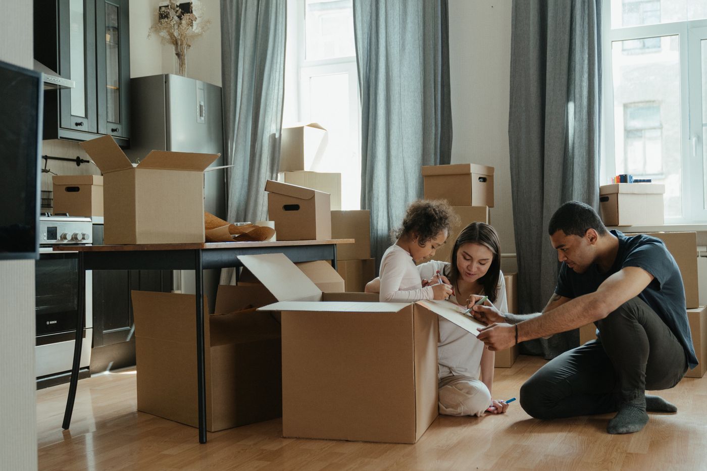A family unpacking moving boxes together in their new kitchen