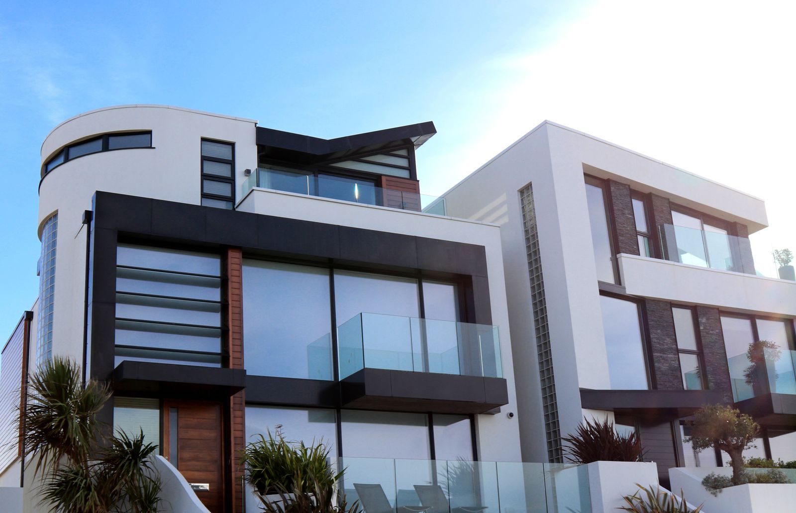 Modern townhomes with glass balconies on a sunny day